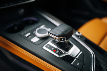 Handle of supercar automatic transmission shift stick. Gearbox of modern car close up. Luxury sport car control panel