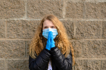 Portrait of sad caucasian child in face mask on closed playground outdoor. Coronavirus social distance quarantine.