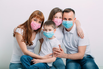 young family in medical masks during home quarantine.