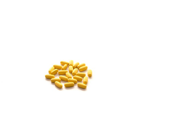 Heap of yellow pills isolated on white background. Healthcare and Medicine.
