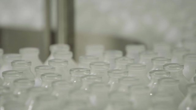 glass bottles on medical solution conveyor line close up selective focus medical industry