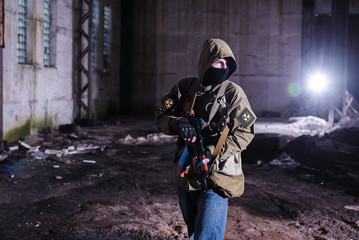 Fototapeta premium Armed stalker warrior in destroyed hangar