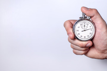 a man's hand with a stopwatch on a white background in the left part of the text space