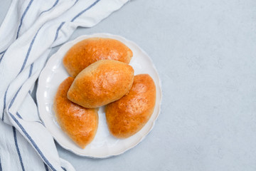 Russian traditional pies pirozhki (stuffed buns) on white plate