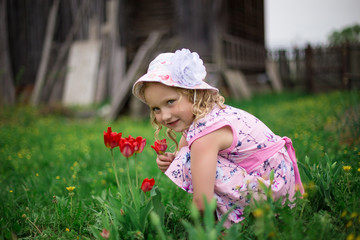 Fototapeta premium little girl playing with flowers