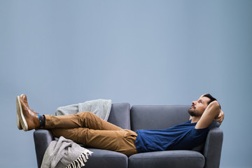 Man Relaxing On Sofa At Home - Powered by Adobe