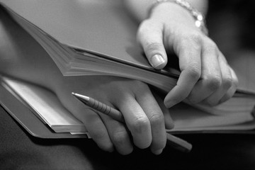 Close up of hands on books of conversation participant listening and waiting.