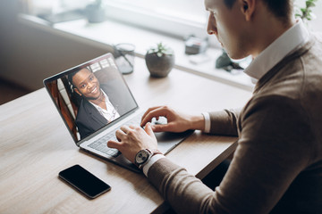 Business partners communicate via video using laptop. The guy talks with his business partner...