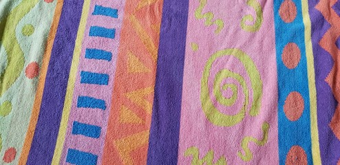 Colorful beach towel with varied patterns and fun designs. 