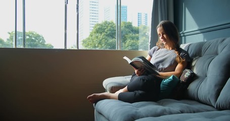 Woman reading a book inside her house