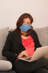 young woman with laptop, and using mask protection due covid-19