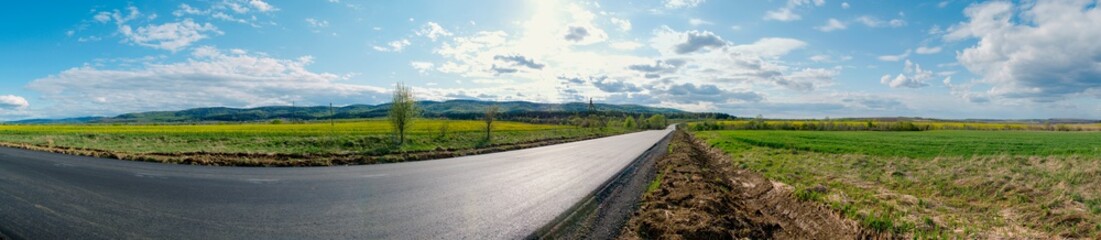 Fototapeta na wymiar Empty asphalt road and fields with mountains on a sunny day