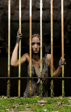 A psychopathic woman is seen in jail. She is
filthy and her clothes are rags. Her expression
is scary and shows she has a disorder. 