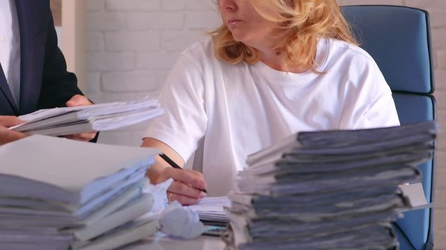 A businesswoman is overloaded by work with data.