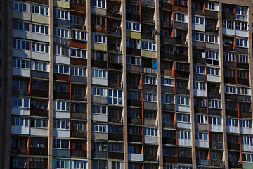 loggias of a tall brick apartment building in a residential area of the city