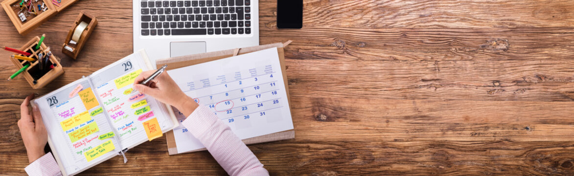 Businesswoman Writing Schedule In Calendar Diary