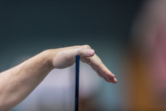 Closeup Of Hand Resting On Glass Divider