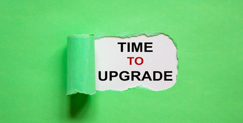 The text 'time to upgrade' appearing behind torn green paper.