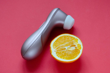 Sex toy. Vibrator and orange on a red background. Useful for sex shop, adult