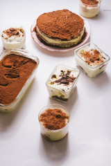 Tiramisu in different shape, various form of serving tiramisu, on glasses, classic, and as a round cake,