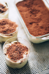 Tiramisu in different shape, various form of serving tiramisu, on glasses, classic, and as a round cake,