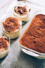 Tiramisu in different shape, various form of serving tiramisu, on glasses, classic, and as a round cake,