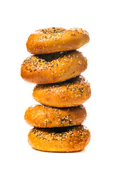 Stack Bagels Topped with Sesame Seeds, Poppy Seeds, Garlic and Onion Isolated on White Background. Selective focus.