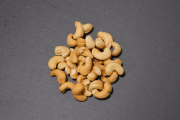 Salted cashew nuts on a black background. Healthy snack