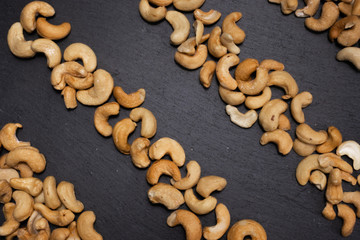 Salted cashew nuts on a black background. Healthy snack
