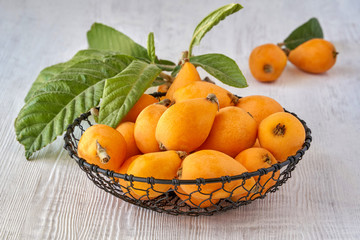 Loquat Medlar fruit with leaves on wooden table