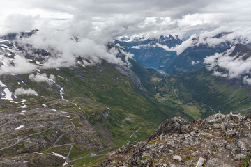 View to Geiranger fjord and eagle road in cloudy weather from Dalsnibba mountain, serpentine road, Norway, selective focus.