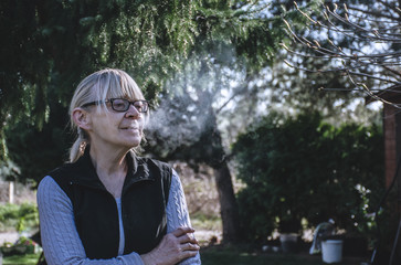 Photo of smoking woman in her 60s. Cinematic and mysterious vibe.