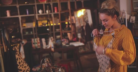 Blonde woman shopping for swimsuits in a vintage boutique store - Powered by Adobe