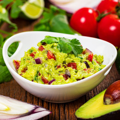 Avocado Guacamole Mexican Dip with Avocado, Lime, Tomato and Cilantro. Selective focus.