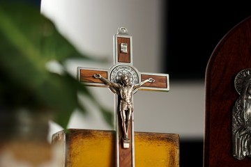 Detalle de crucifijo de madera con bordes y detalles en metal plateado.