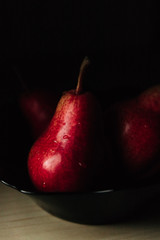 two red pear red bartlett in low key in the black plate
