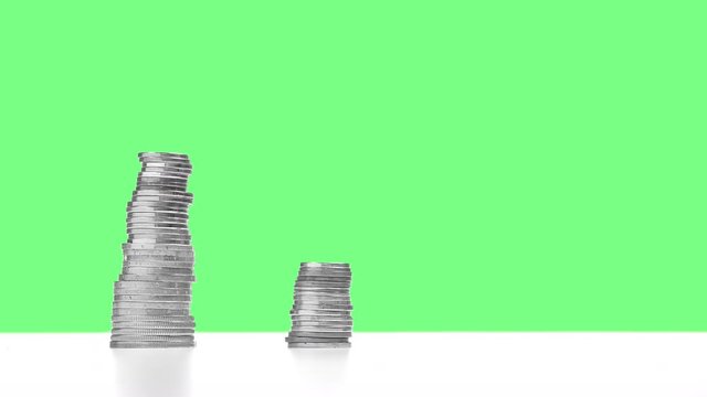 Concept of economic recession, crisis, business crash, or financial collapse. Time lapse of four stacks of silver coins on green screen.