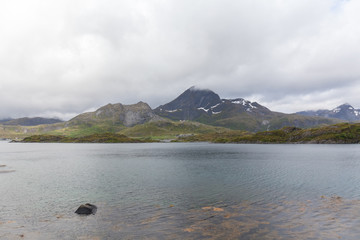 Beautiful view of the Norwegian fjords with turquoise water surrounded by cloudy sky, selective focus