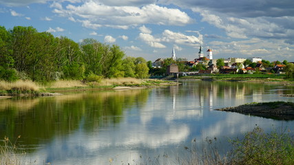 miasto wiosną nad rzeką Odrą z błękitnym niebem i burzowymi chmurami