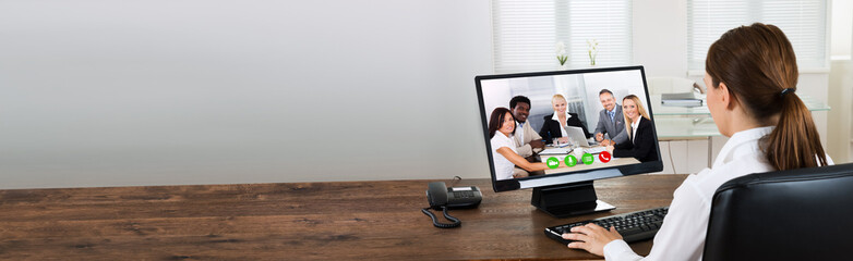 Businesswoman Videochatting With Colleagues On Computer