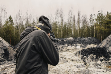 Fototapeta premium A guy shoots from a hunting rifle on the shooting range in the desert sporting shooting. background. free space for text