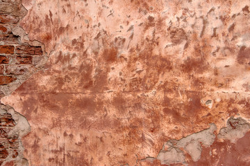 Shabby old building facade with damaged plaster. Old brick wall texture. 