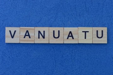 country name from the gray word vanuatu from wooden letters in black font lies on a blue table