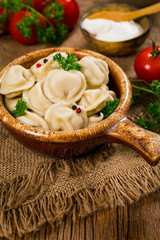 Beef and Pork Dumplings - Russian and Ukrainian Meat Pelmeni on Wooden Background. Selective focus.