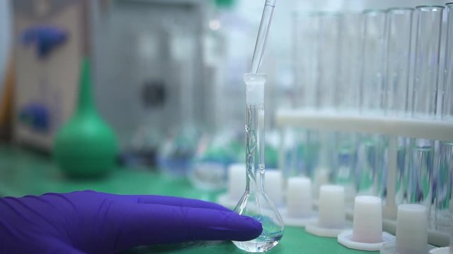 pouring liquid into flask using pipette. Spbd medical pharmaceutical experiment in laboratory. scientific expertise. chemist hand working with lab beaker equipment.