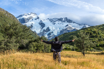 Obraz premium Man with open arms during at Mount Cook, New Zealand ..