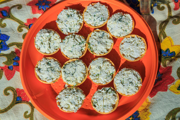 top view closeup orange plate with homebaked tasty snacks with cottage cheese filling