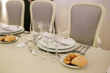 Protocol of distribution of plates, cutlery and glasses on a luxury table in a restaurant