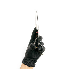 Gloved hand holding a black scisors on an isolated white background