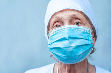 Portrait of an elderly woman doctor in medical equipment outfit. Tired look at the doctor's clinic. Epidemic coronavirus. People's health. Pandemic covid-19. Experienced Senior Physician